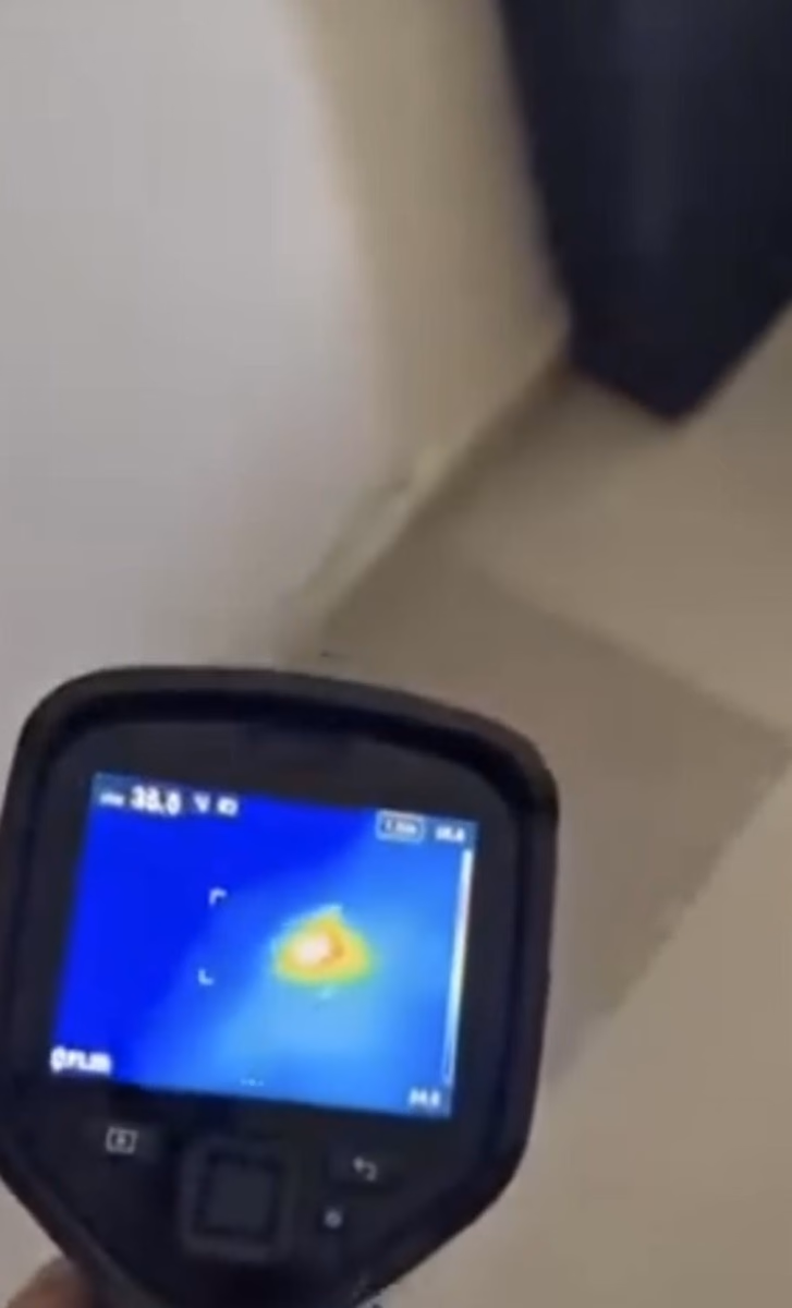 מסך מצלמה תרמית המכוון אל אזור חשוד בקיר